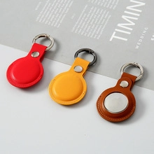 Close-up of small leather coin purses in red, yellow, and brown with metal keychains