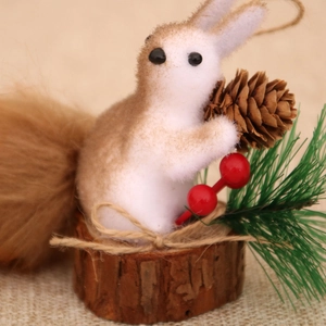 Detailed view of artificial squirrel ornament with pine cone on a wooden base