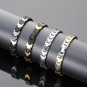Detail of four stainless steel magnetic bracelets in black, silver, and gold finishes