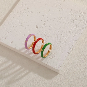 Detailed macro view of colorful enamel rings with small diamonds on white stone base