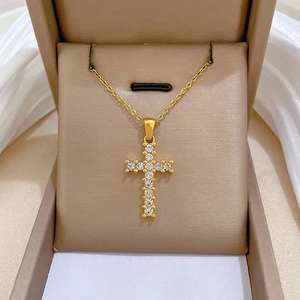 Elegant gold titanium steel cross necklace with cubic zirconia in a jewelry box