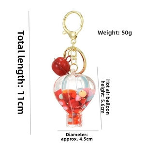 Detailed view of acrylic hot air balloon keychain with red liquid and golden metal clasp