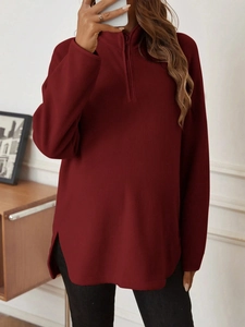 Close-up of dark red polar fleece texture and zipper detail on maternity long sleeve top
