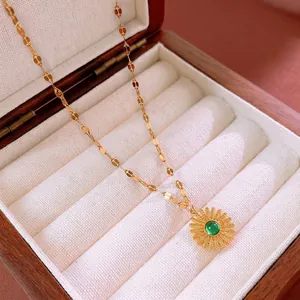 Vintage stainless steel sunflower necklace with green gemstone on a beige gift box liner