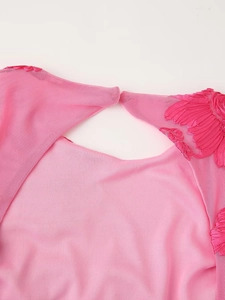 Détail macro du tissu en maille rose avec broderie plume et applique florale délicate