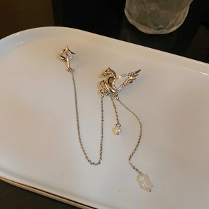Close-up of a silver Pegasus brooch with star charms, sparkling zircons and a white pearl