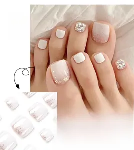 Détails macro des faux ongles de pieds blancs avec paillettes roses et strass