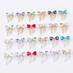 Détails de bijoux d'ongles en forme de nœuds colorés avec rubans en cristal sur blanc
