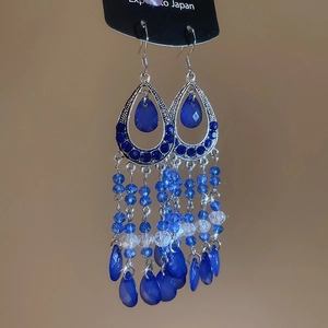 Detail of bohemian drop earrings with blue crystal inlay and layered beaded fringe