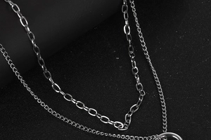 Detail of silver double-layered necklace featuring thick cable and thin curb chain links