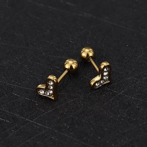 Detail of golden heart-shaped screw back earrings with sparkling cubic zirconia inlay