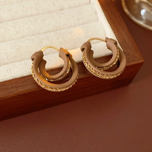 Dettaglio di orecchini a cerchio a doppio strato placcati oro con inserti in resina