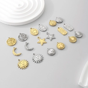 Detailed macro view of assorted gold and silver sun, moon and star charms in stainless steel