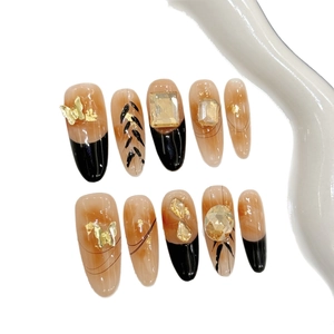 Amber marble press-on nails with golden butterfly and rhinestone accents, long oval shape
