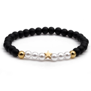 Minimalist beaded bracelet with black matte beads, white pearls, and gold star charm