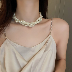 Detail of elegant multilayer pearl necklace with sparkling rhinestone shoulder strap