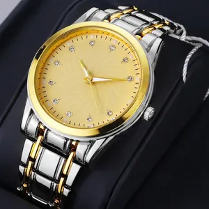 Macro detail of gold dial with diamond markers and calendar on steel watch