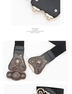 Detail of vintage carved metal buckle and black elastic wide waist belt for women