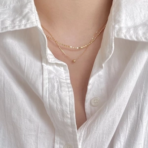 Double-layered 925 silver necklace in gold finish with delicate bead and disc charms