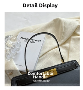 Detail of elegant black faux leather handbag with golden lock and slim curved handle