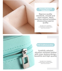 Detail of mint green PVC leather jewelry box with cross texture and silver metal zipper