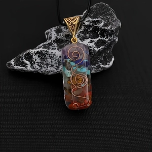 Macro shot of rectangular resin pendant with colorful natural stones and copper spiral wire