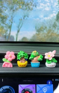 Detail of four cute car dashboard plant ornaments with Chinese lucky inscriptions
