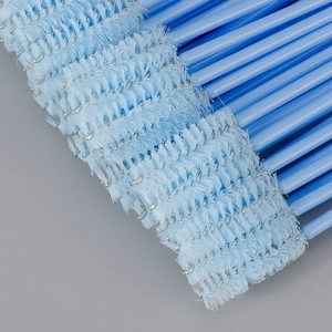 Macro shot of disposable eyelash and eyebrow brushes with light blue handles and soft bristles