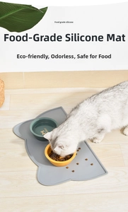 Macro shot of a cat eating on a grey cat-shaped waterproof food-grade silicone mat