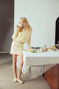 Close-up of cream yellow knit cardigan set with soft texture and button detailing