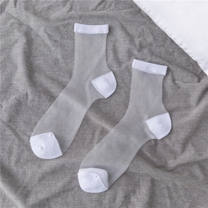 Sheer white mesh crew socks with reinforced knit toes and heels on a linen background