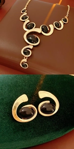 Detail view of vintage gold necklace and oval black stone earrings jewelry set