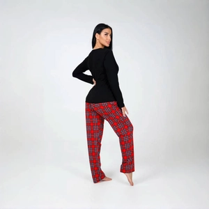 Détail du pantalon de pyjama à carreaux rouge et bleu avec haut noir à manches longues