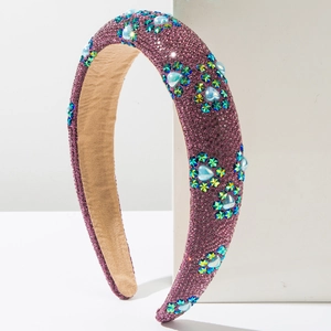 Detailed macro view of sparkling purple headband with star-shaped crystals and blue heart gem