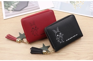 Detail view of red and black PU leather coin purses with tassels and cute rabbit patterns