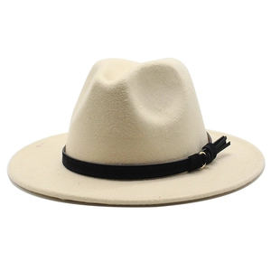 Dettaglio cappello fedora in lana crema con nastro nero, bottone dorato e nappa