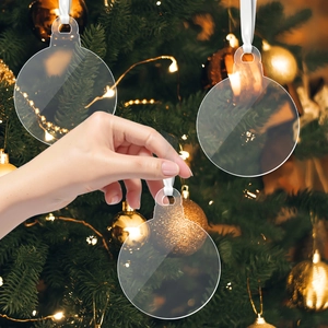 Close-up of clear round acrylic snowflake ornament with white ribbon on Christmas tree