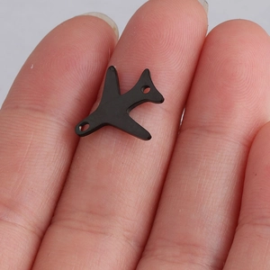 Black stainless steel airplane pendant with double holes held between two fingers