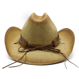 Dettaglio cappello cowboy in paglia con fascia etnica e pendente a foglia d'argento