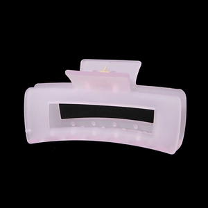 Gros plan sur une pince à cheveux rectangulaire rose pâle mat évidée