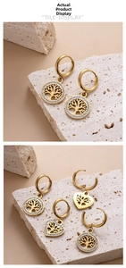 Detail of gold Tree of Life earrings with hollow engravings and white zircon accents