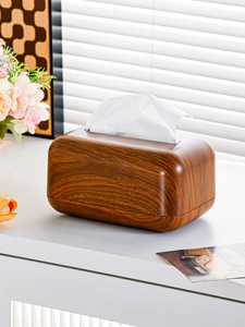 Detail of walnut wood finish tissue box with white base on a minimalist home desk
