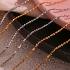 Detail of 18K gold and silver plated stainless steel S-link chains with polished texture