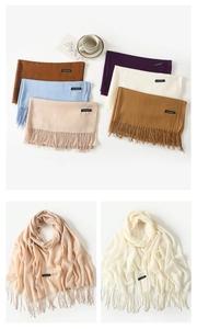 Close-up of multicolored faux cashmere scarves with fringe details and woven labels
