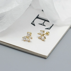 Macro detail of gold bow stud earrings with sparkling cubic zirconia and screw backs