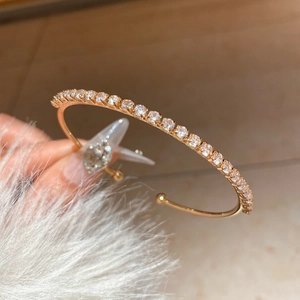 Close-up of 18K gold plated bangle featuring a row of sparkling cubic zirconia stones
