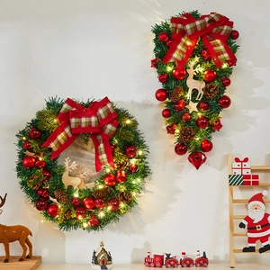 Detail of Christmas wreath with LED lights, red baubles, pine cones and reindeer decor