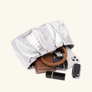 Silver metallic crocodile embossed evening bag showing interior capacity and everyday essentials
