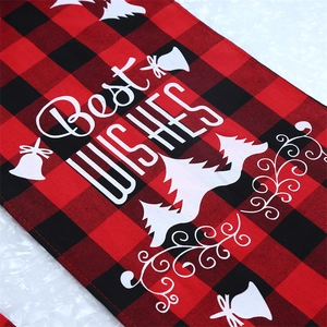 Detail of red and black plaid Christmas table runner with Best Wishes white print