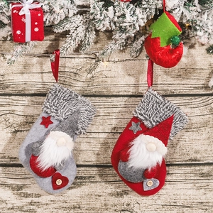 Festive red and grey Christmas stockings with forest gnome dolls on a rustic wood background